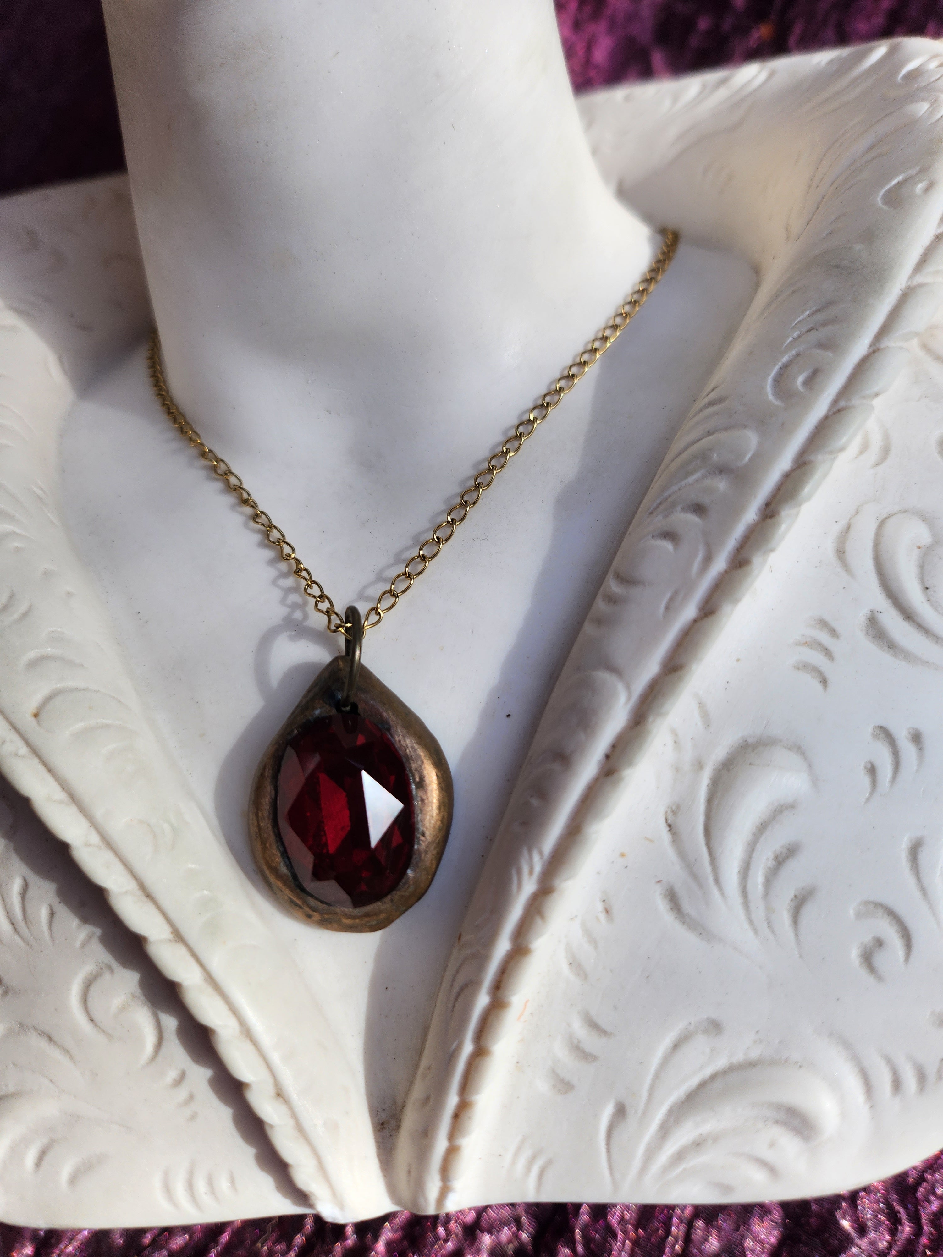 Pendente artesanal em bronze com cristal vermelho escuro.