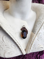 Coleção Ressonância Arcana – Pendente artesanal em cobre com cristal oval castanho