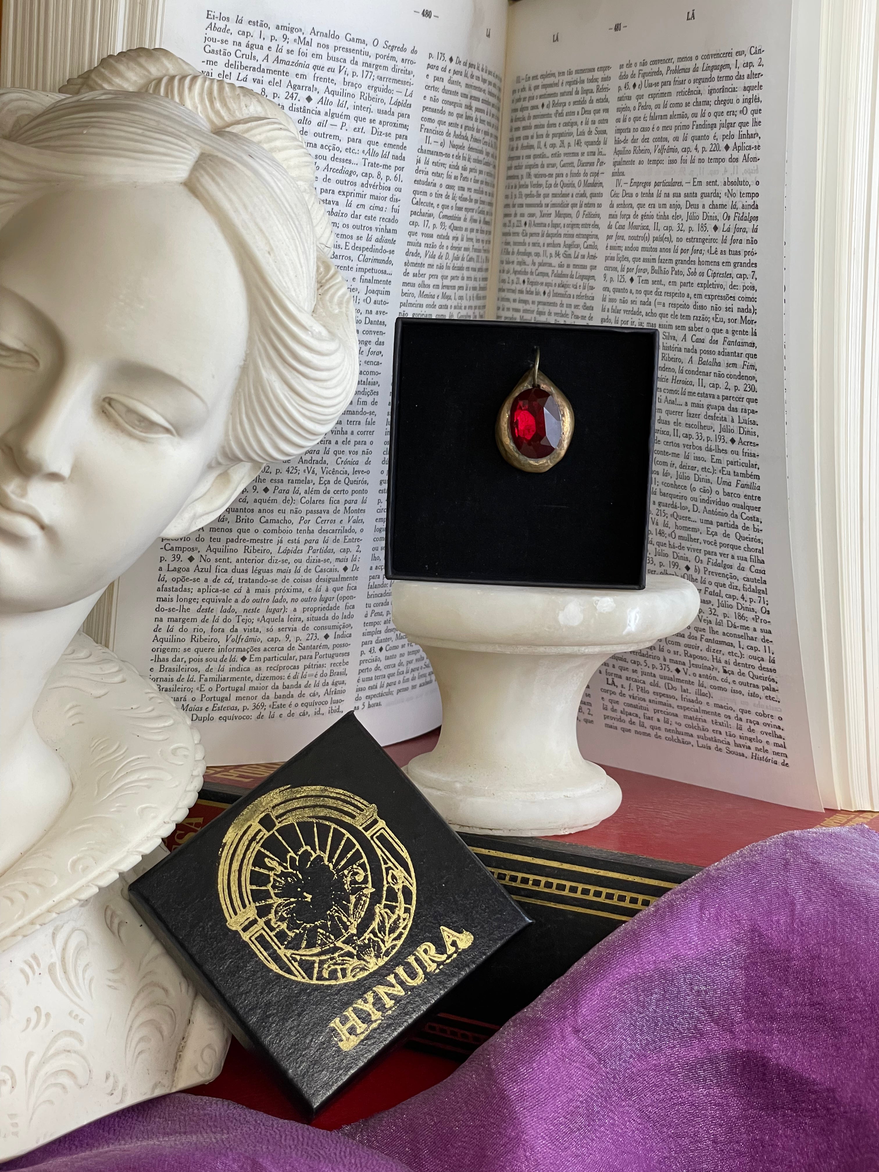 Pendente artesanal em bronze com cristal vermelho escuro.