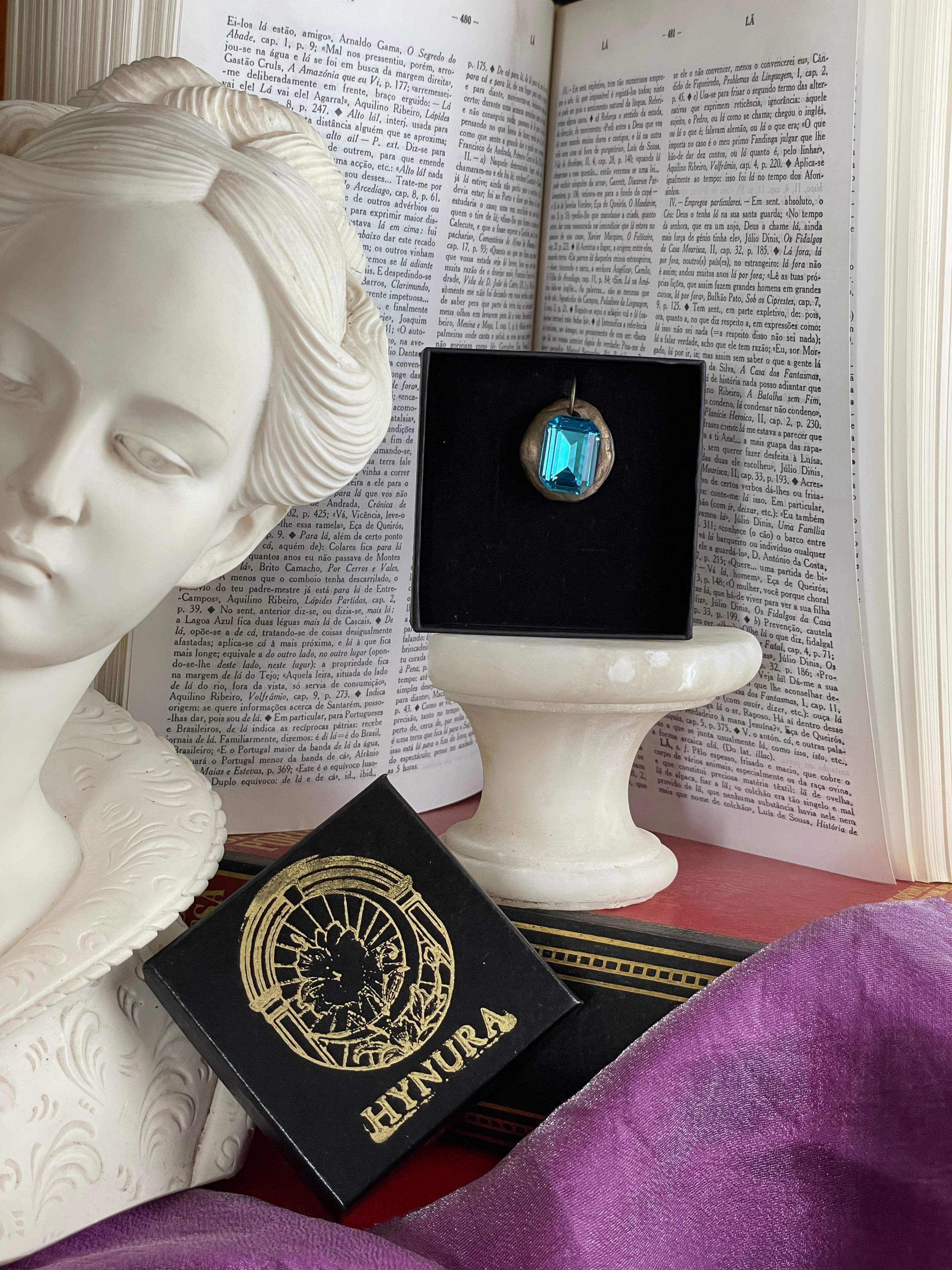 Pendente artesanal em bronze com cristal azul.