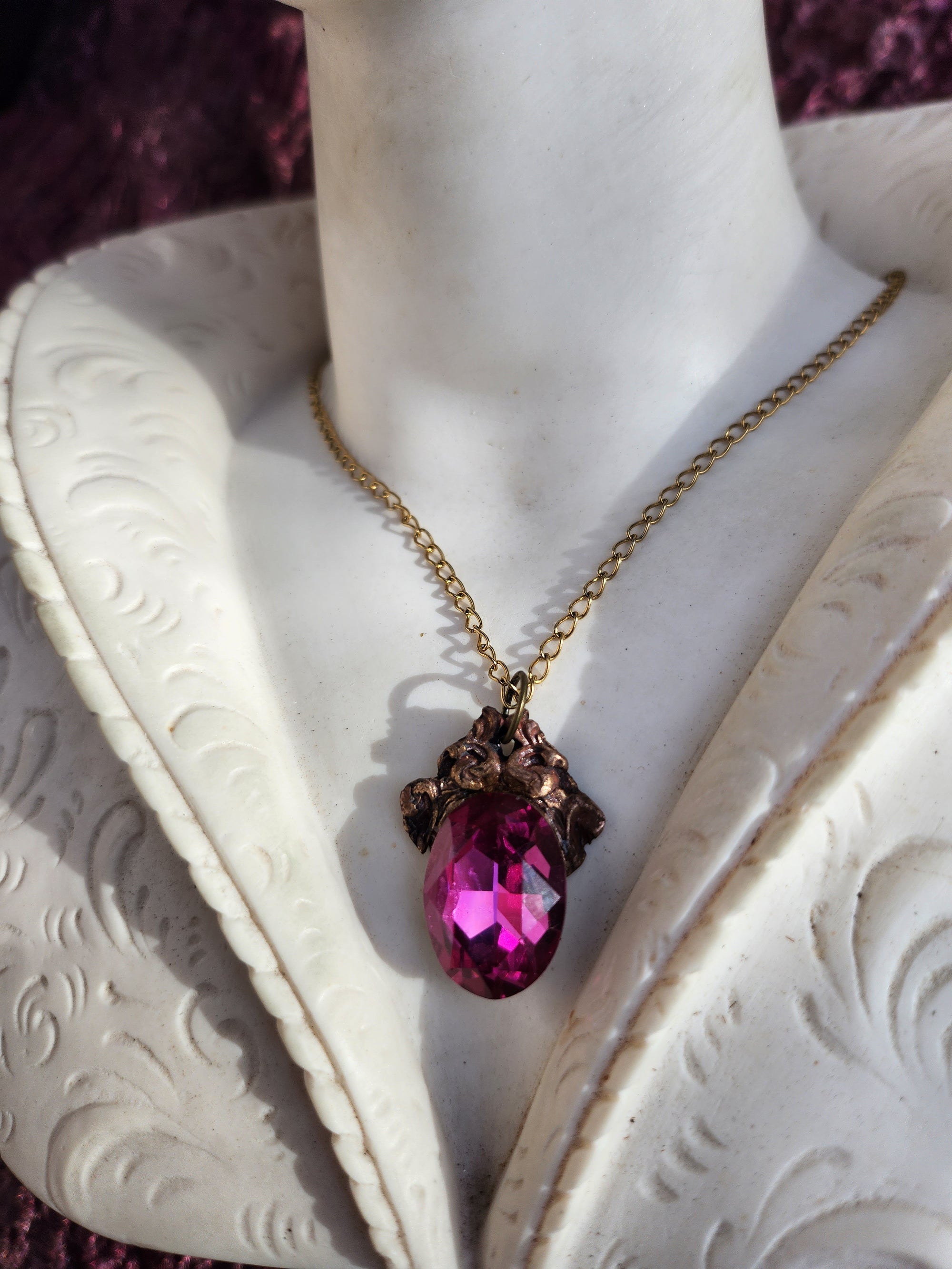 Colgante de bronce artesanal con cristal fucsia: joyería gótica única.