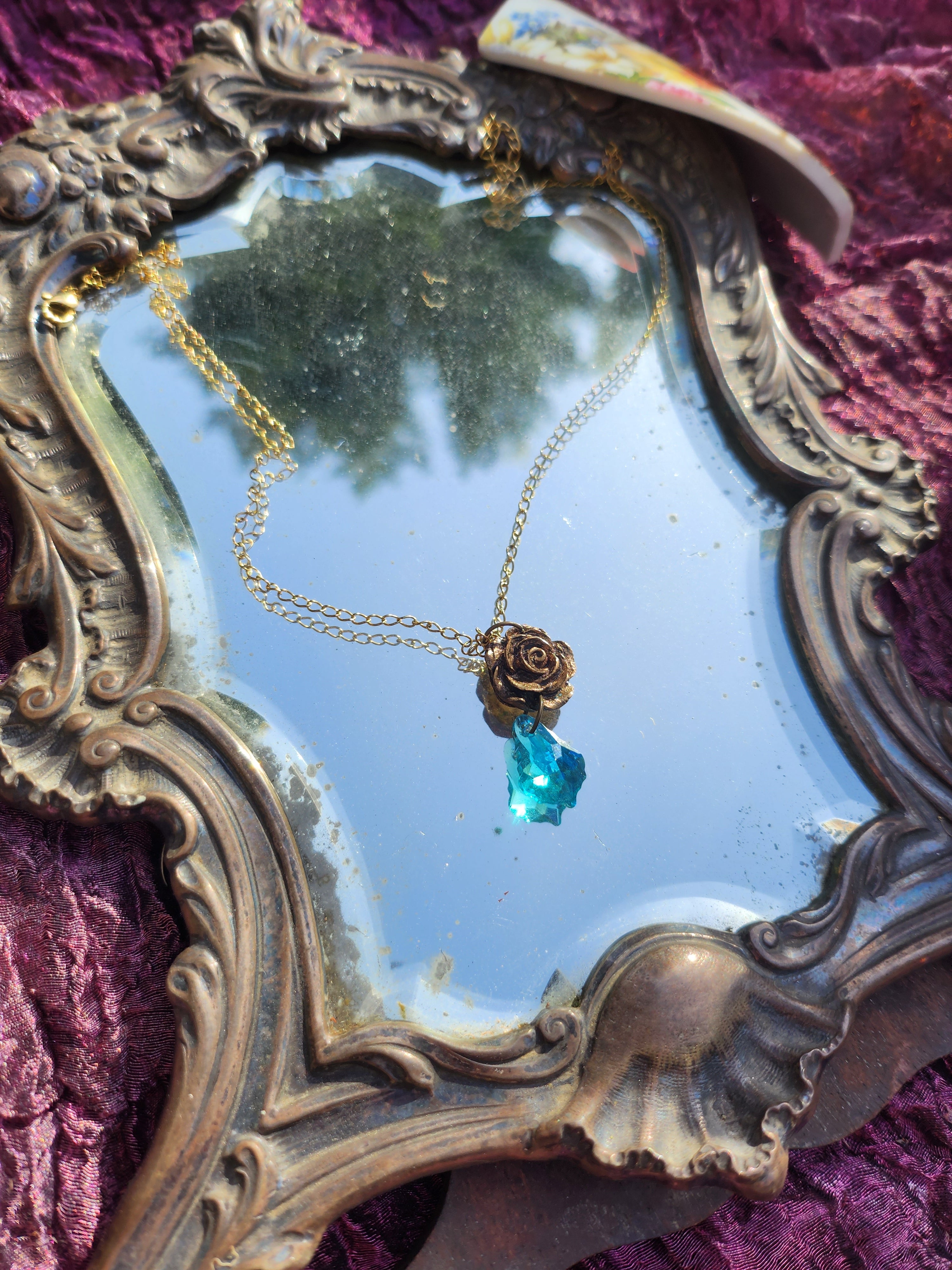 Coleção Rosarium - Pendente de rosa artesanal em bronze com cristal azul claro