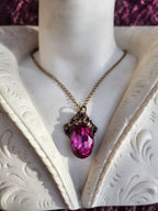 Colgante de bronce artesanal con cristal fucsia: joyería gótica única.