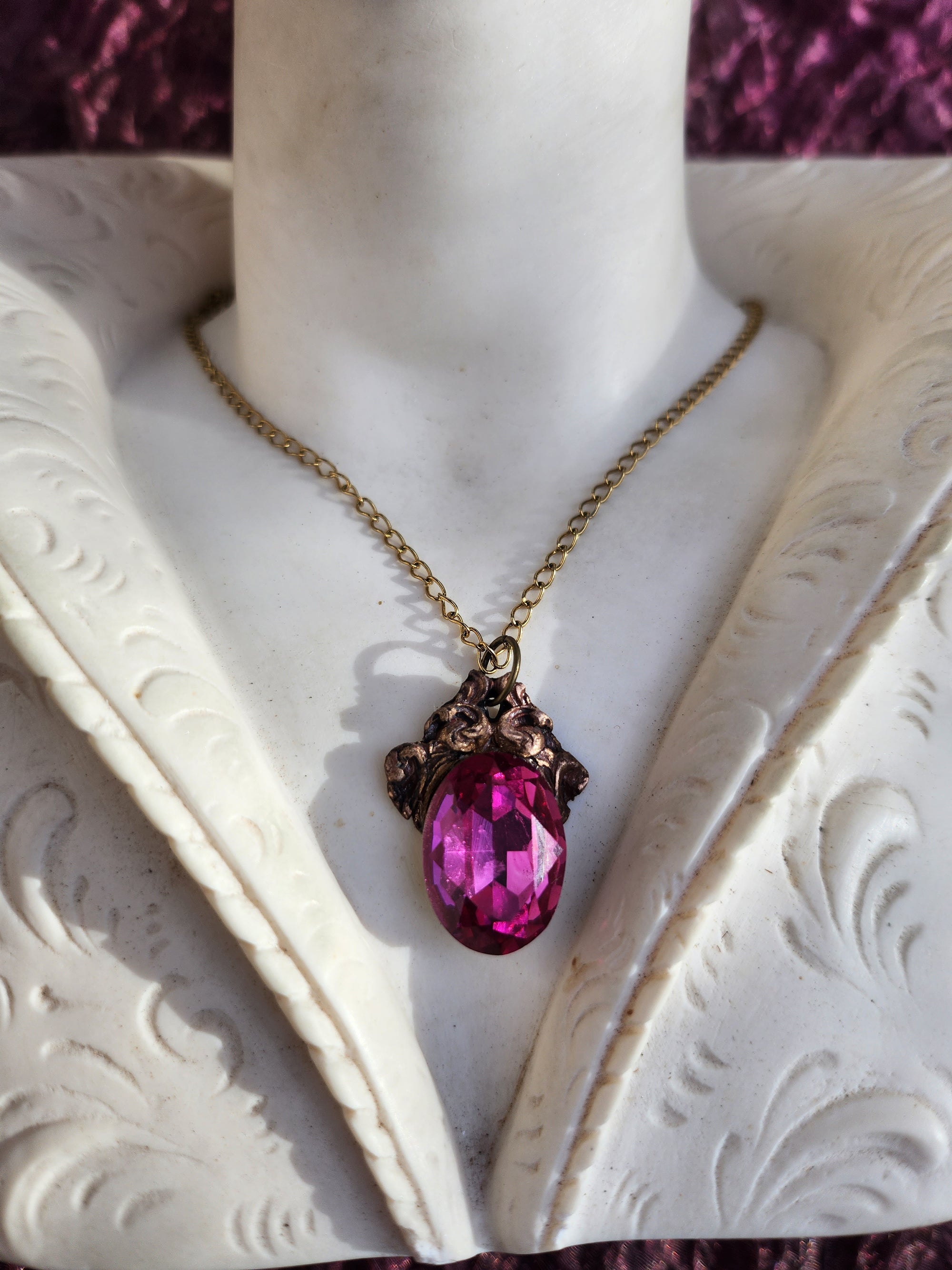 Colgante de bronce artesanal con cristal fucsia: joyería gótica única.
