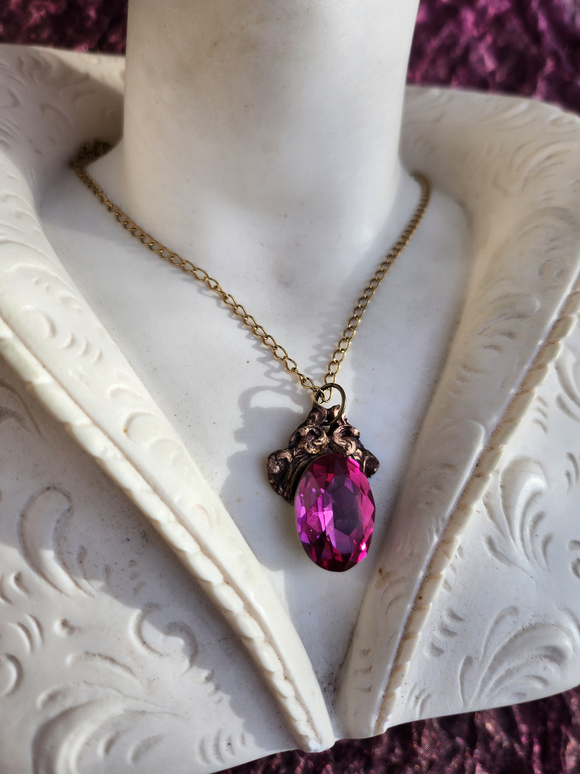 Colgante de bronce artesanal con cristal fucsia: joyería gótica única.
