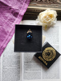 Coleção Ressonância Arcana – Pequeno Pendente Artesanal em Bronze com Cristal Oval Azul Escuro