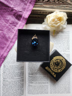 Coleção Ressonância Arcana – Pequeno Pendente Artesanal em Bronze com Cristal Oval Azul Escuro