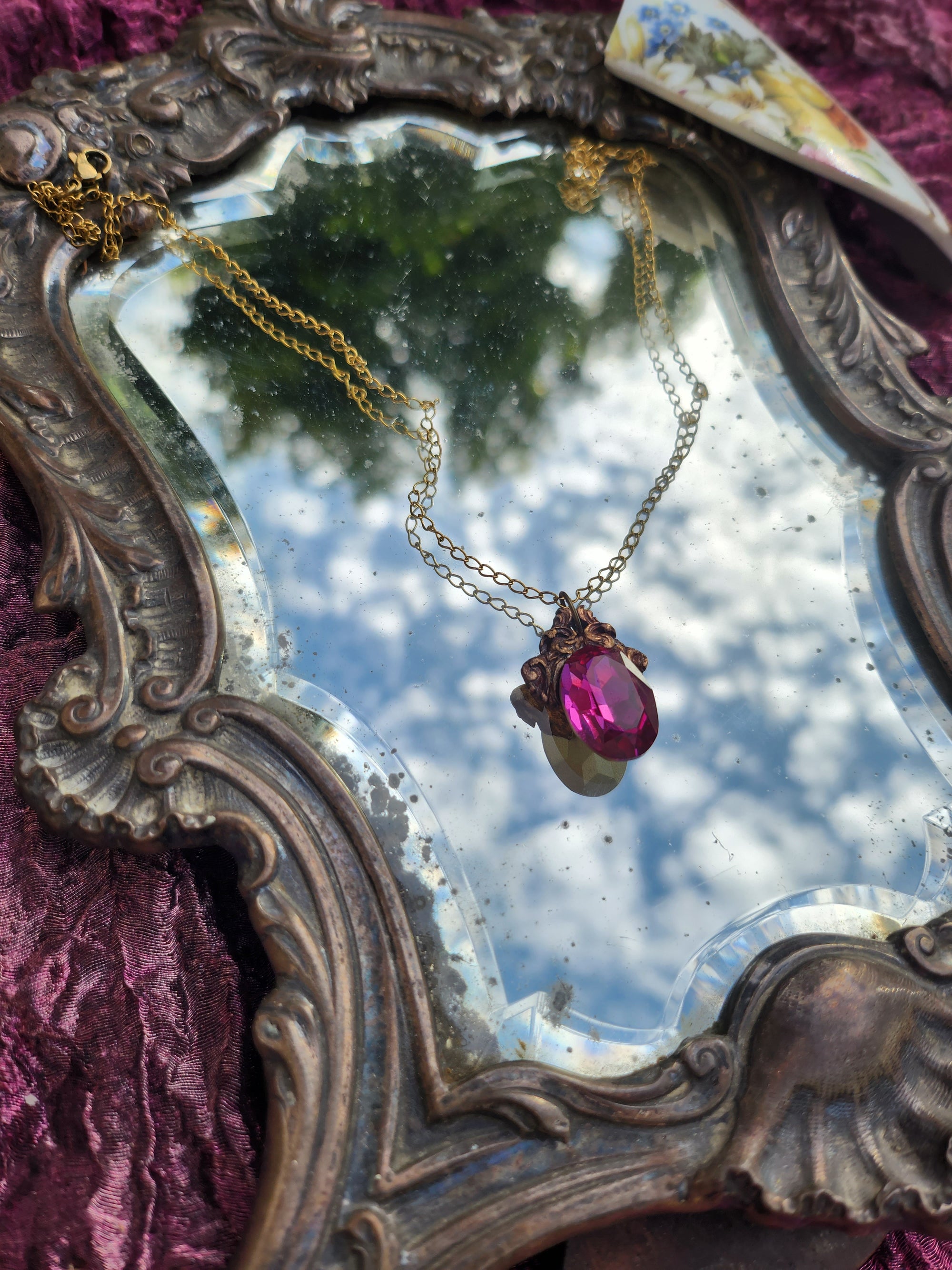 Colgante de bronce artesanal con cristal fucsia: joyería gótica única.